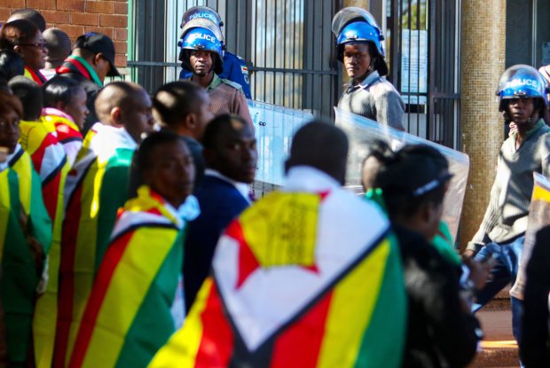 Zimbabwe anti-riot police guard the entrance at the Harare magistrate's court where pastor Evan Mawarire was due to appear in court on charges of inciting public violence following his arrest ahead of a planned mass job stayaway on July 13, 2016. / AFP PHOTO / Jekesai NjikizanaJEKESAI NJIKIZANA/AFP/Getty Images